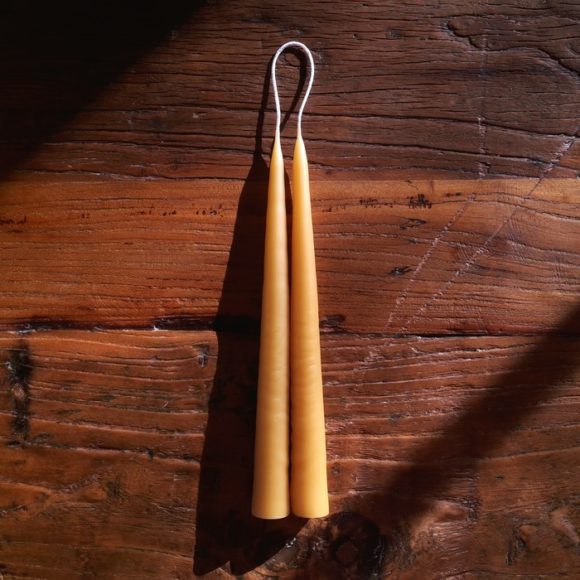 Hand dipping golden beeswax candles