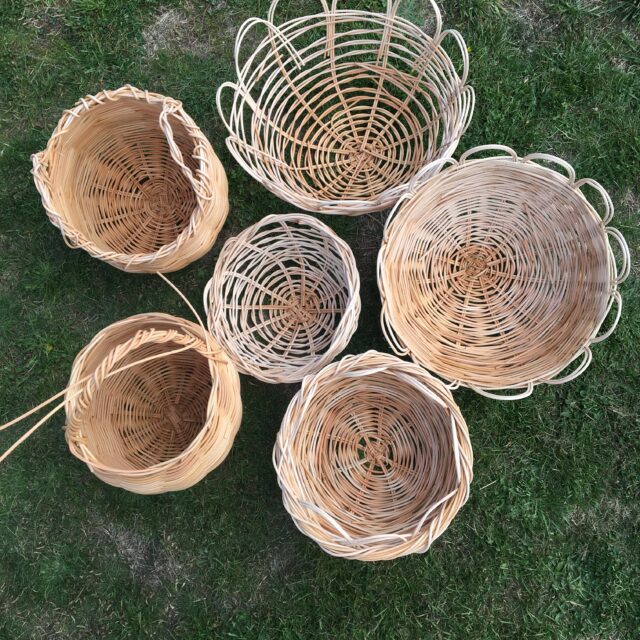 A collection of handwoven cane baskets on grass