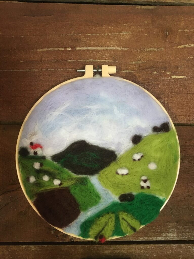 A finished needle-felted Tasmanian landscape in an embroidery hoop