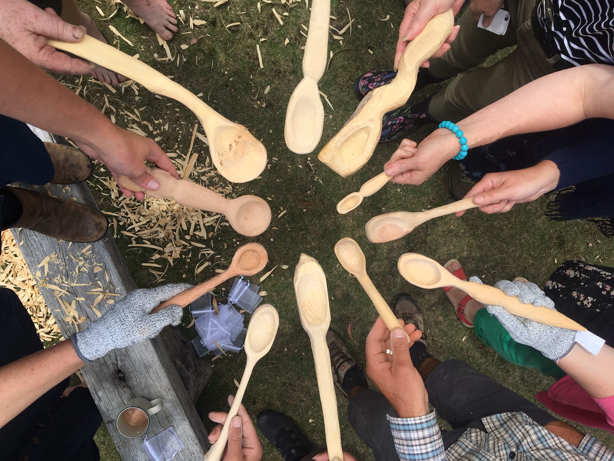 A Forest Folk workshop group showing their hand-carved wooden spoons